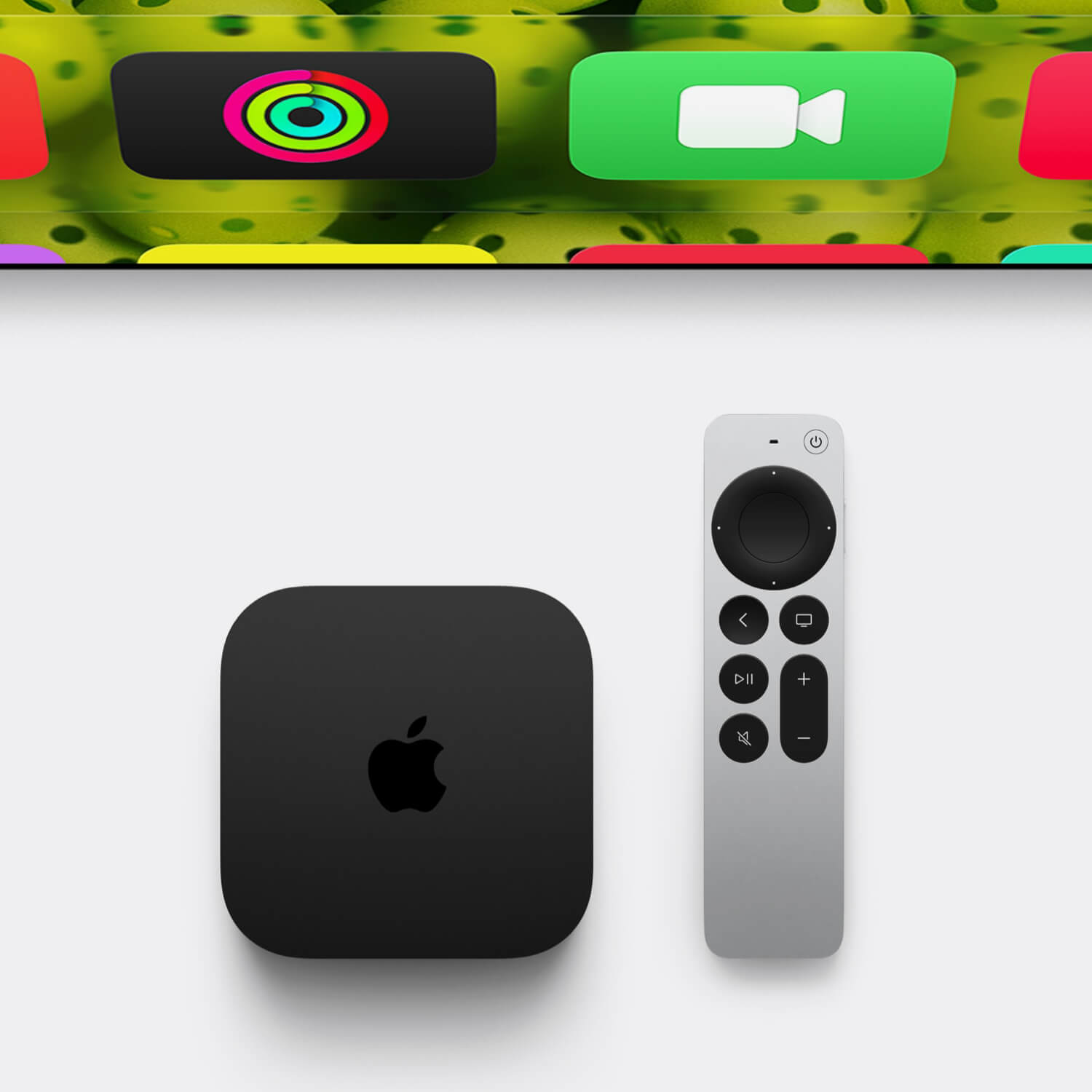 An Apple TV 4K and the Siri remote next to a TV.
